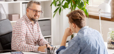 Jeune homme passant son entretien annuel dans le bureau de son responsable