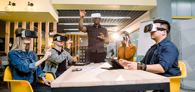 5 personnes qui font une réunion en portant des casques de réalité virtuelle